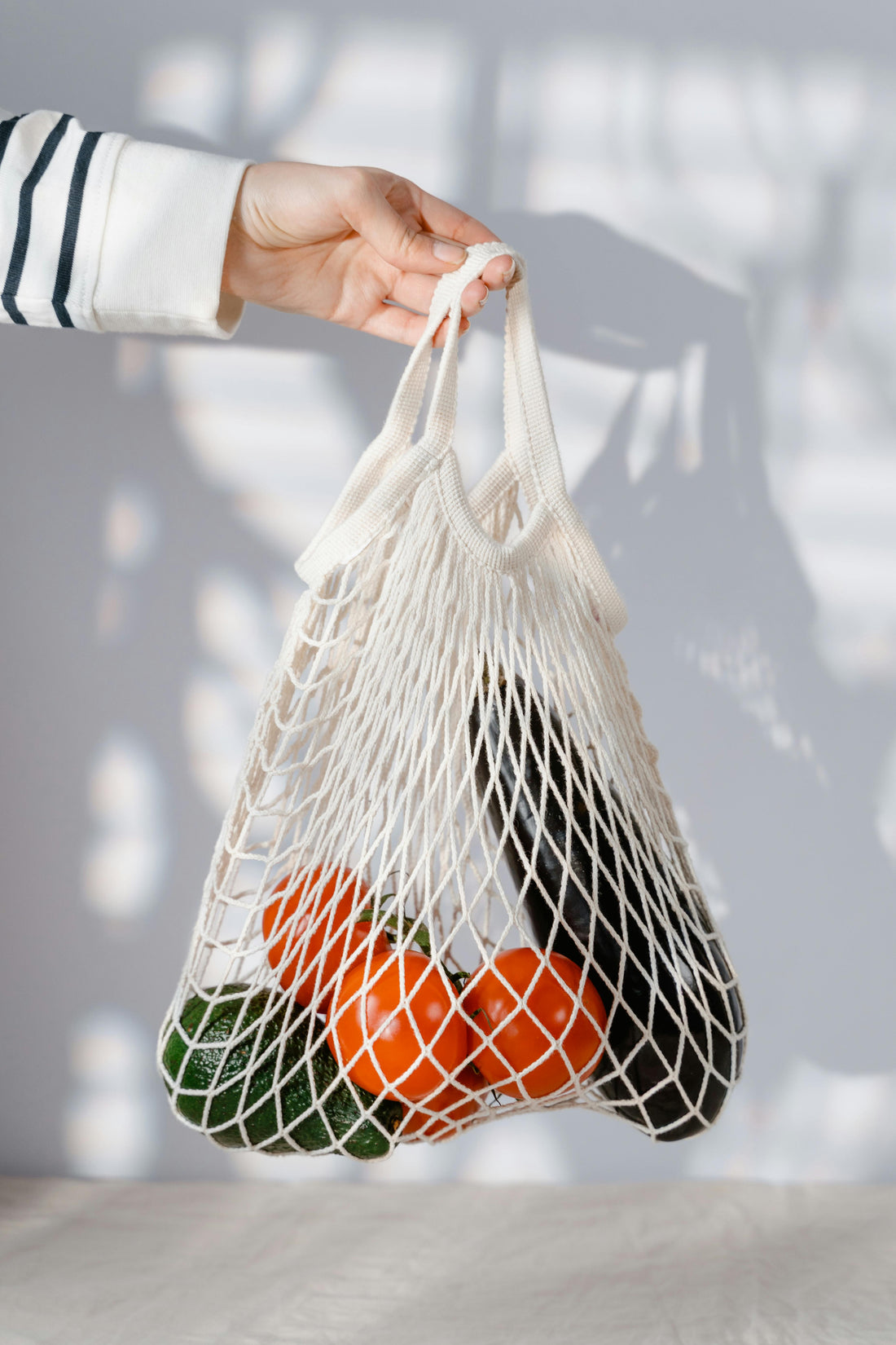 Reusable grocery bag filled with fresh groceries, including vegetables and packaged items, symbolizing sustainable shopping and saving.