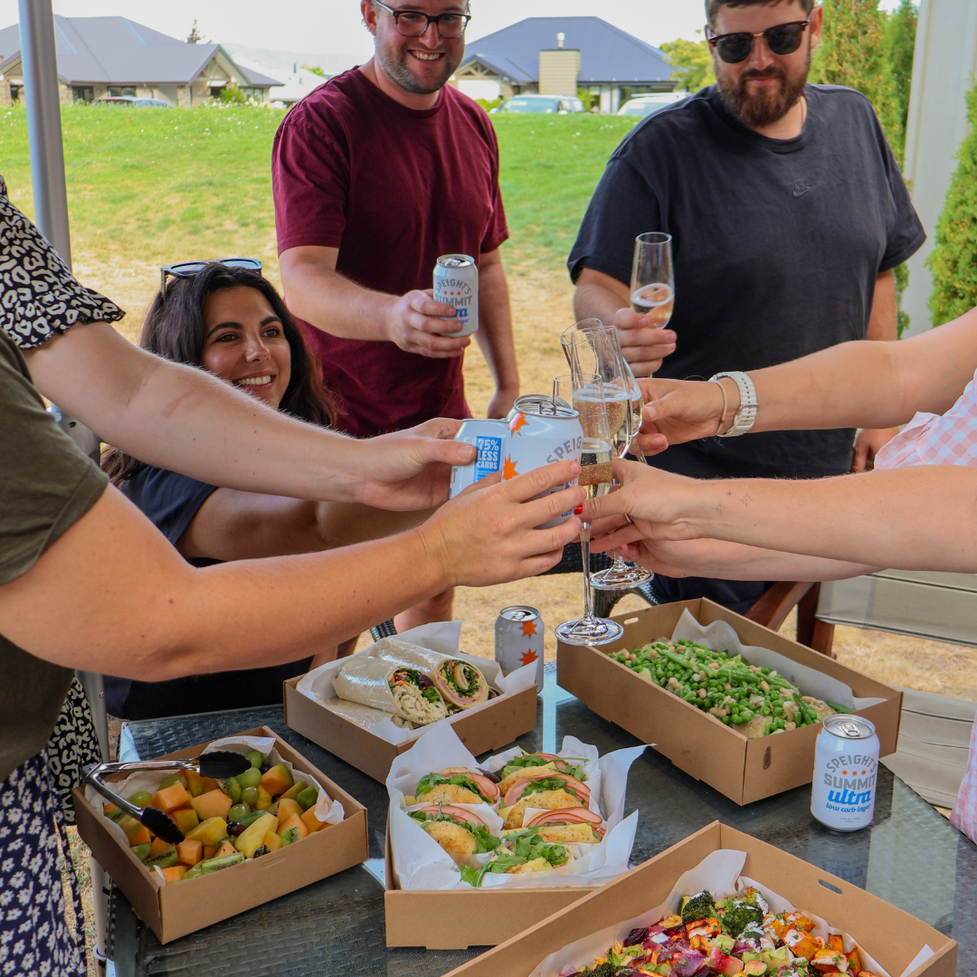 Group of people enjoying a outdoor gathering with food and drinks.