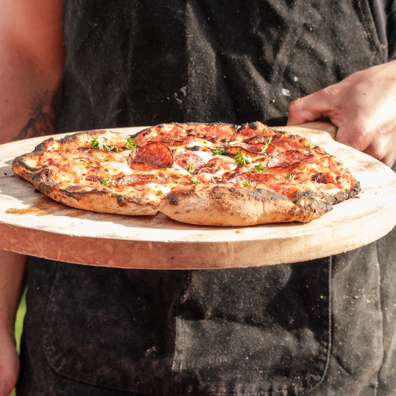 Pizza on a wooden board outdoors