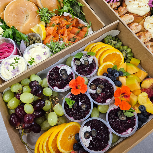 Assorted food items including fruits, vegetables, and pastries in a box.