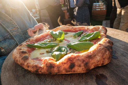 Pizza with spinach on a wooden board outdoors