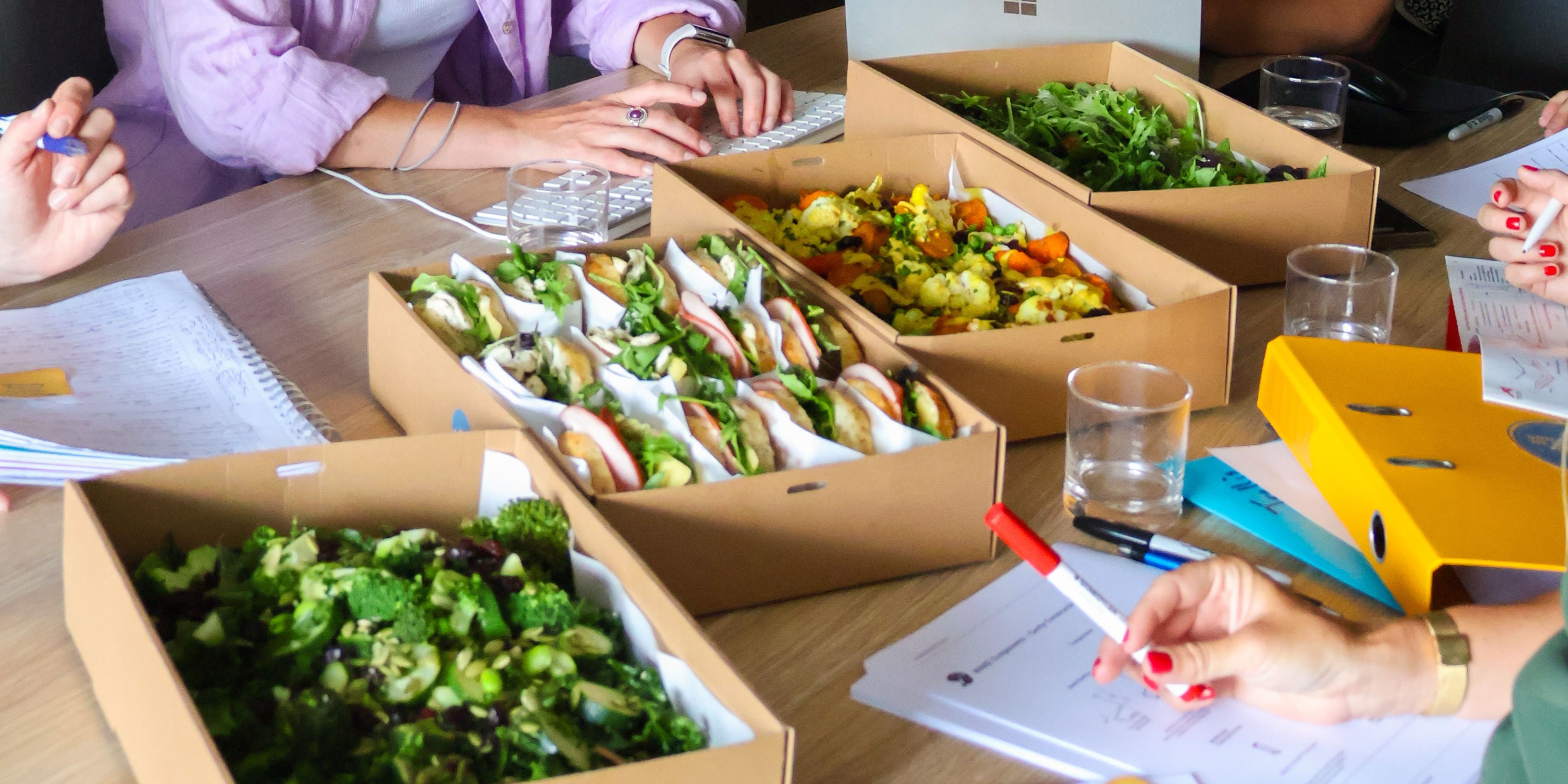 Fresh catering menu featuring colorful vegetables, sandwiches, and salads